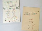 deux cartes sur lesquelles sont dessinés des visages, posées sur une table