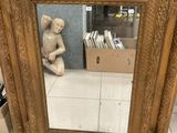 a mirror that is sitting on the floor next to a statue