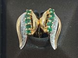 un gros plan sur une paire de boucles d'oreilles ornées de pierres vertes