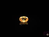 a yellow sapphire stone on a black surface