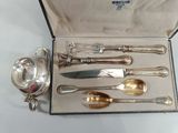 a silverware set in a box with a knife, spoon, and spoon rest