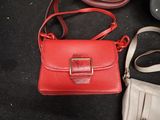 a red purse and a white purse on a black surface