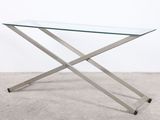une table en verre avec des pieds en métal et un plateau en verre