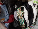 a pile of clothes in a suitcase on the floor