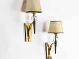 pair of brass sconces with lamps on a white wall