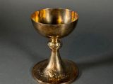 an antique silver plated cup on a stand on a grey background