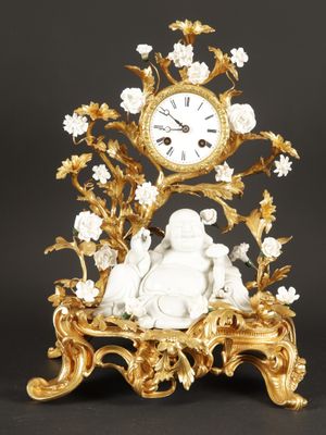 a clock that is sitting on a table with a statue on it