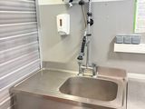 a sink and a trash can in a small room
