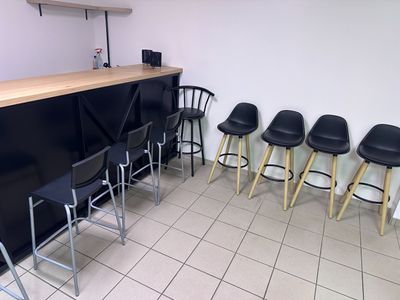 quatre tabourets noirs placés devant un comptoir dans une pièce