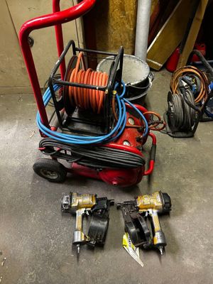 un chariot rouge avec un tuyau et d'autres outils posés par terre