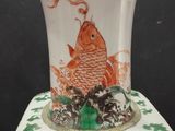 a white vase with a gold fish design on it