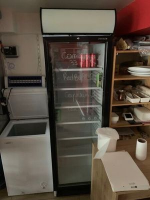 un réfrigérateur qui se trouve dans le coin d'une pièce