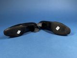 the bottom of a pair of black shoes on a blue surface