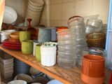 many plates and bowls on the shelves in the kitchen