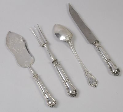 quatre cuillères en argent, un couteau et une fourchette posés sur une table