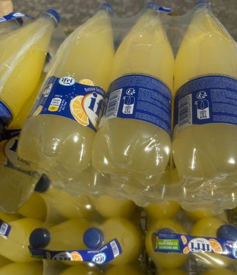de nombreuses bouteilles de jus d'orange exposées dans un magasin