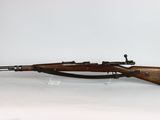 the rifle is on display on a clear stand