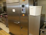 stainless steel refrigerators in a commercial kitchen with pots and pans hanging from the ceiling