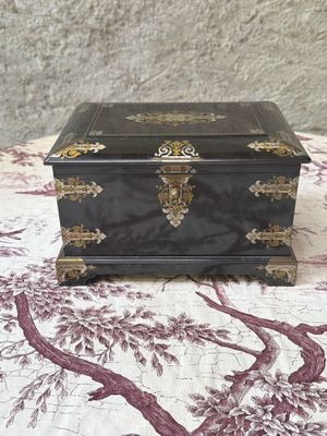 a small black box sitting on a table with a tree in the background