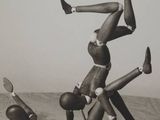 a black and white photo of a man doing a handstand on another man