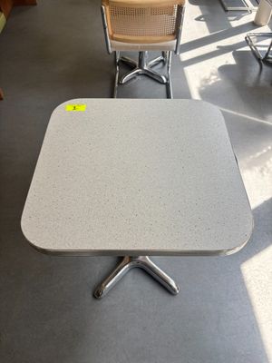 des tables et des chaises dans une pièce où il y a un autocollant jaune sur la table