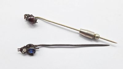 deux épingles posées sur une surface blanche