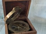 a small wooden box with a metal lid on display