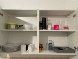 a white cupboard with dishes and cups on it