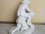 a statue of a boy and a dog sitting on a table
