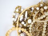 a pile of gold and pearl necklaces and bracelets