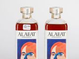 deux bouteilles d'alcool sont posées l'une à côté de l'autre sur une surface blanche