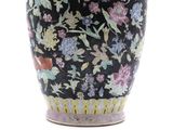 a black vase with a floral design on it