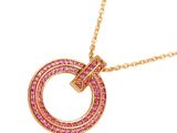 a close up of a pink necklace with a gold chain