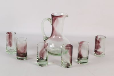bottles and glasses are lined up on a white surface