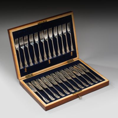 un service d'argenterie dans un coffret en bois posé sur une table