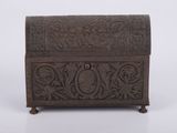 an old wooden box with carvings on it on a white surface