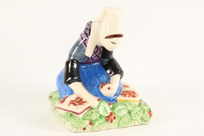 une figurine représentant une femme assise sur un rocher