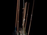 several brooms and a shovel in a vase on a black background
