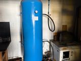 a blue water heater sitting in a room next to a microwave
