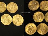 gold coins are arranged in a row on a black surface