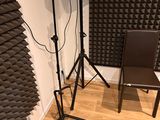 a room with speakers, a chair, and a guitar