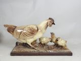 a figurine of a chicken and chicks on a table