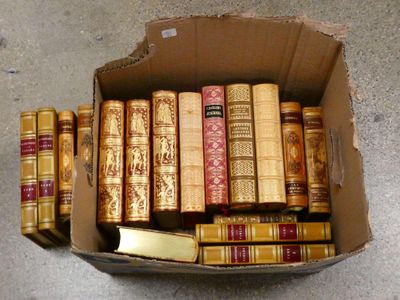 une boîte en carton remplie de vieux livres, posée par terre