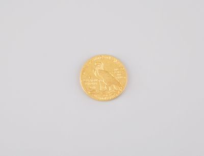 a close up of a gold coin on a white surface