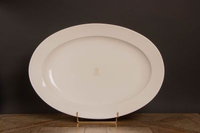 une assiette blanche posée sur une table en bois, sur fond noir