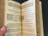 someone is holding an old book open to show the pages