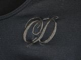 a close up of a black shirt with a monogram on it