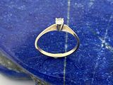 un gros plan d'une bague en diamant posée sur une pierre bleue