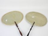 pair of antique wooden and leather hand fans on a white surface