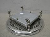 une assiette en argent sur laquelle se trouve un petit objet métallique